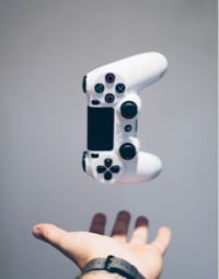 a man hand in the bottom and an X-box controller in the mid air